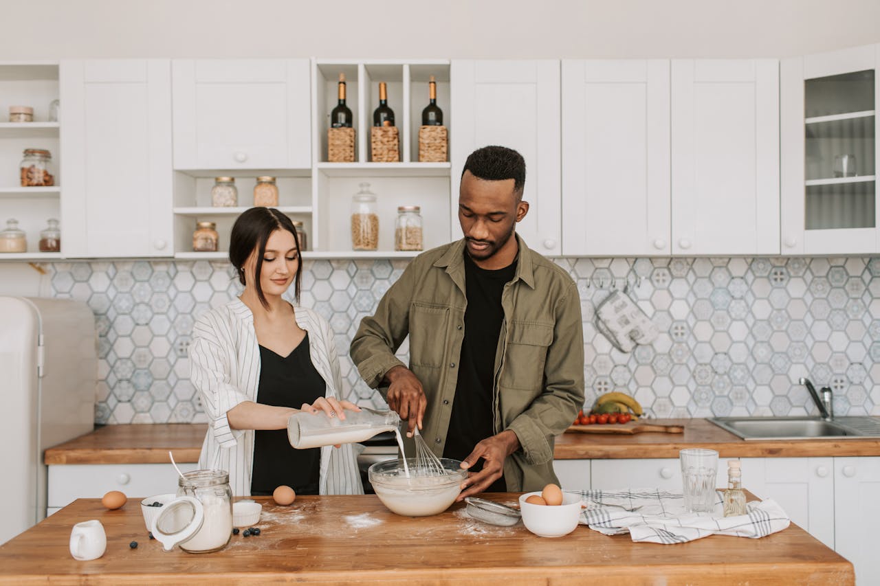A couple collaboratively prepares a meal in a stylish contemporary kitchen setting.
